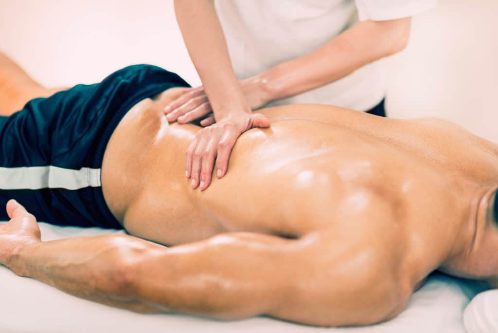 man receiving physical therapy for his lower back pain