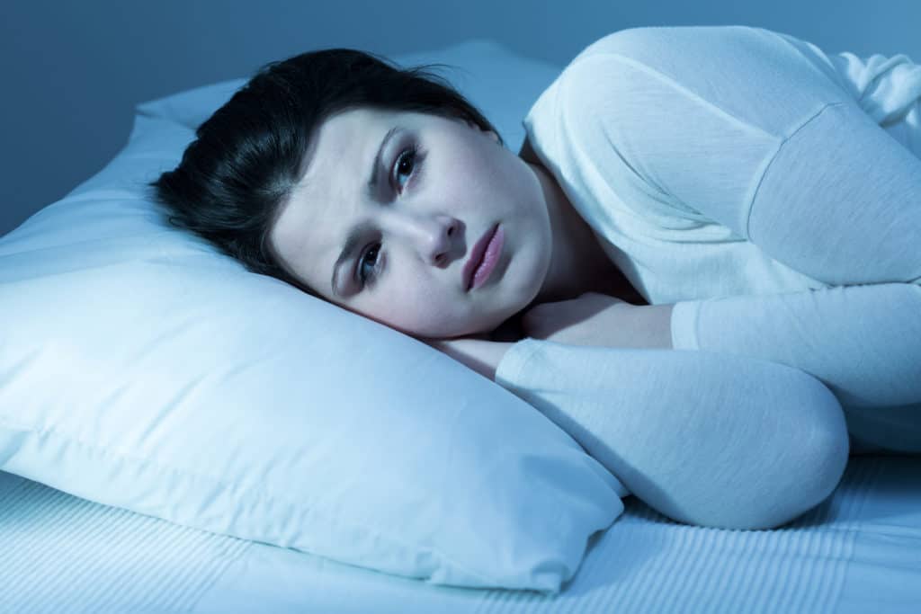 woman lying in bed awake as can't sleep