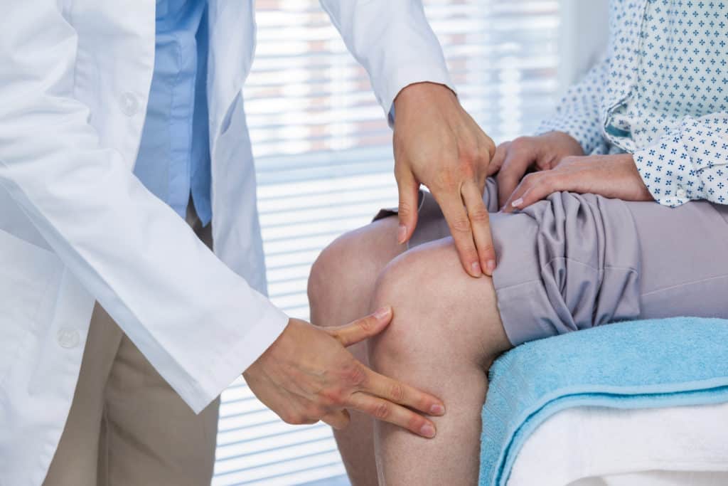 physical therapist checking patients knee