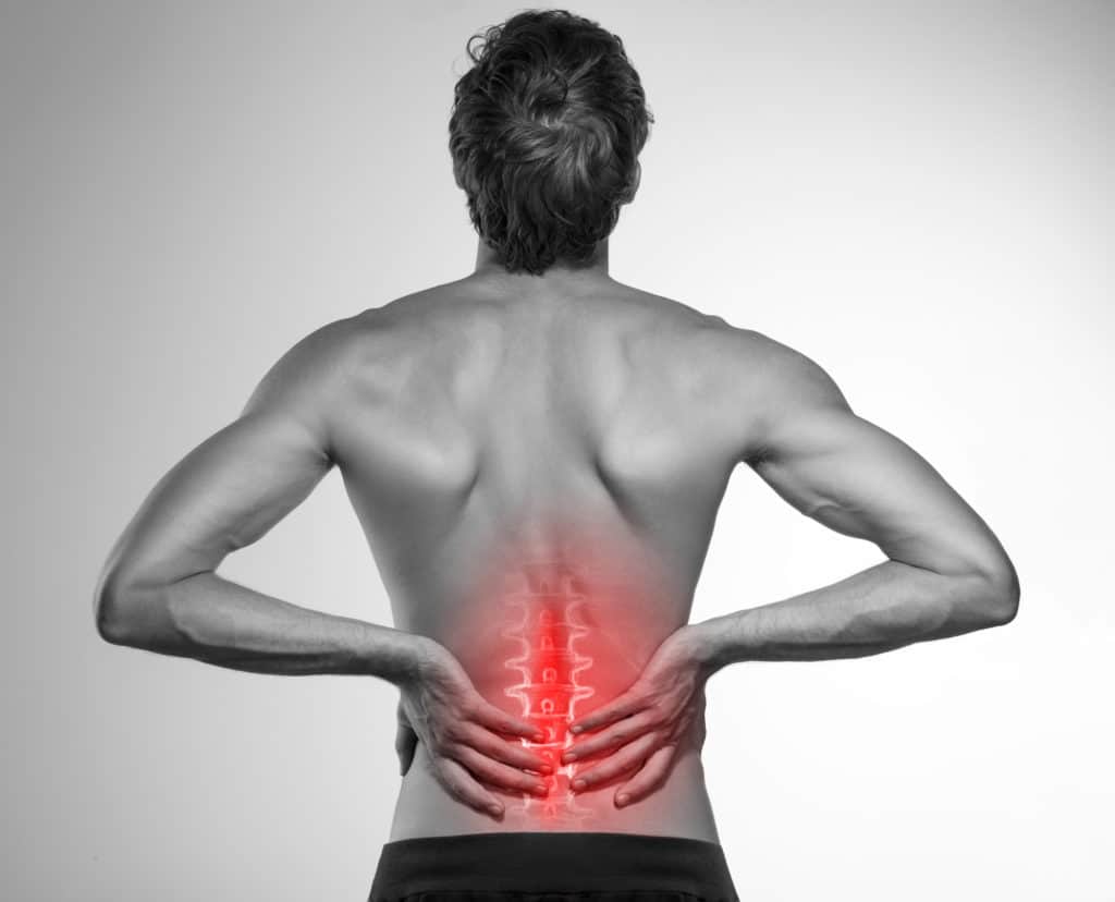 man holding his lower back in pain 