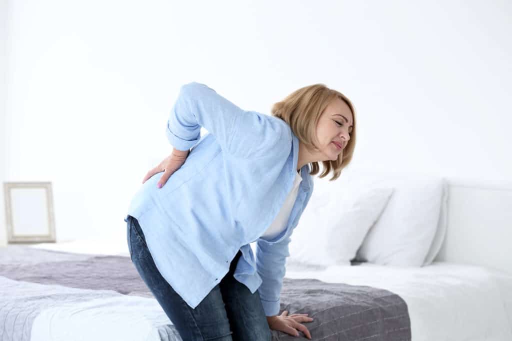 senior woman holding her lower back in pain
