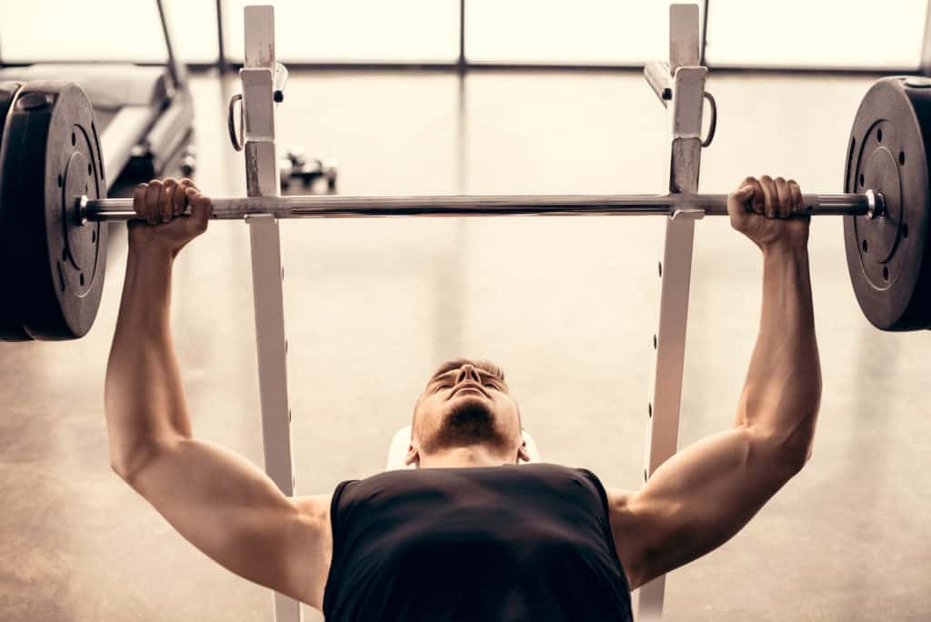 man lifting weights causing shoulder pain