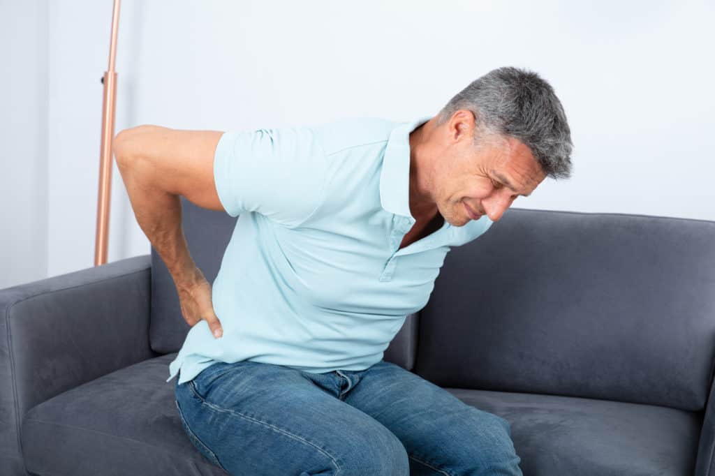 man holding his back from Radiculopathy