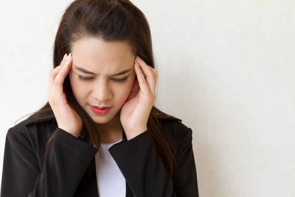 woman with headache, migraine, stress, insomnia, hangover in business executive dress