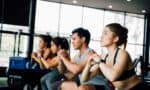 High-intensity workouts Group of athletic young Asian people in sportswear doing squat and exercising at the gym. Intense workout and healthy lifestyle concept