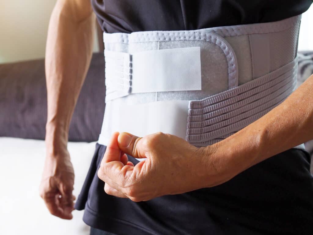 Elderly men with back pain support belt or medical belt, orthopedic lumbar support.