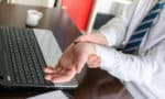Man with carpal tunnel syndrome holding his wrist in pain