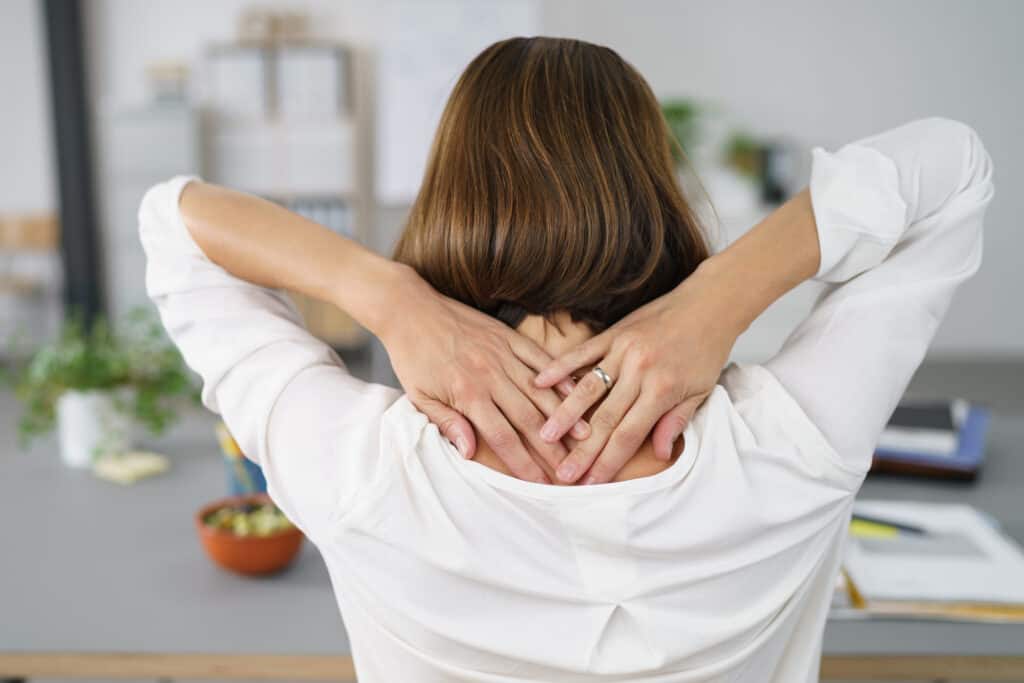 Close up Rear View of a Tired Businesswoman Holding her Nape with Two Hands.