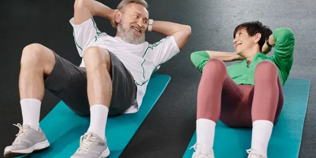 elderly couple exercising side-by-side in the gym