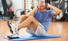 Senior Man Doing Sit Ups In Gym