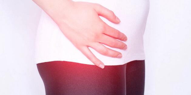 The girl holds on to the hip joint in which pain and inflammation in the thigh