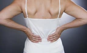 lady holding her back with both hands