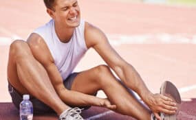 an athlete feeling the pain of a strained muscle