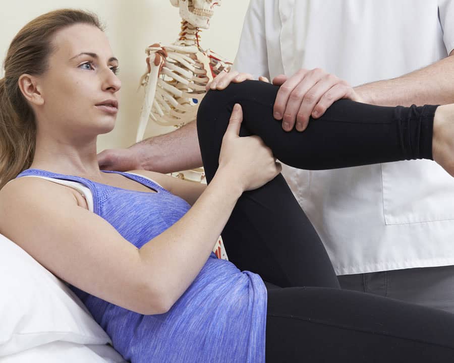 physical therapist Treating Female Patient With Hip Problem