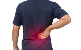 Causes of back spasms man with blue shirt having a back spasm