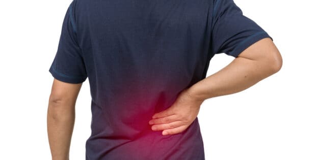 Causes of back spasms man with blue shirt having a back spasm