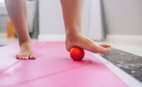 a person's foot on a ball doing Plantar Fasciitis Exercises